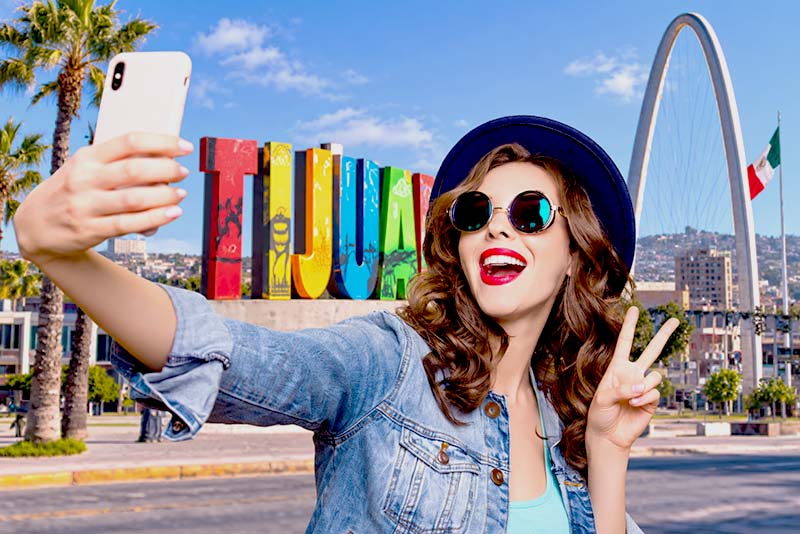 Visitor taking a selfie at the Tijuana sign, a major dental tourism destination